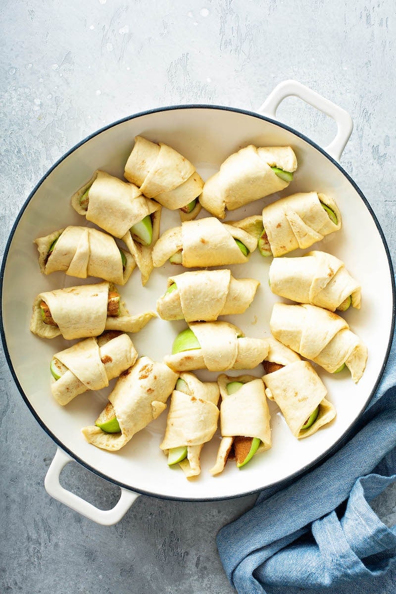 Apple pastries in pan before baking.