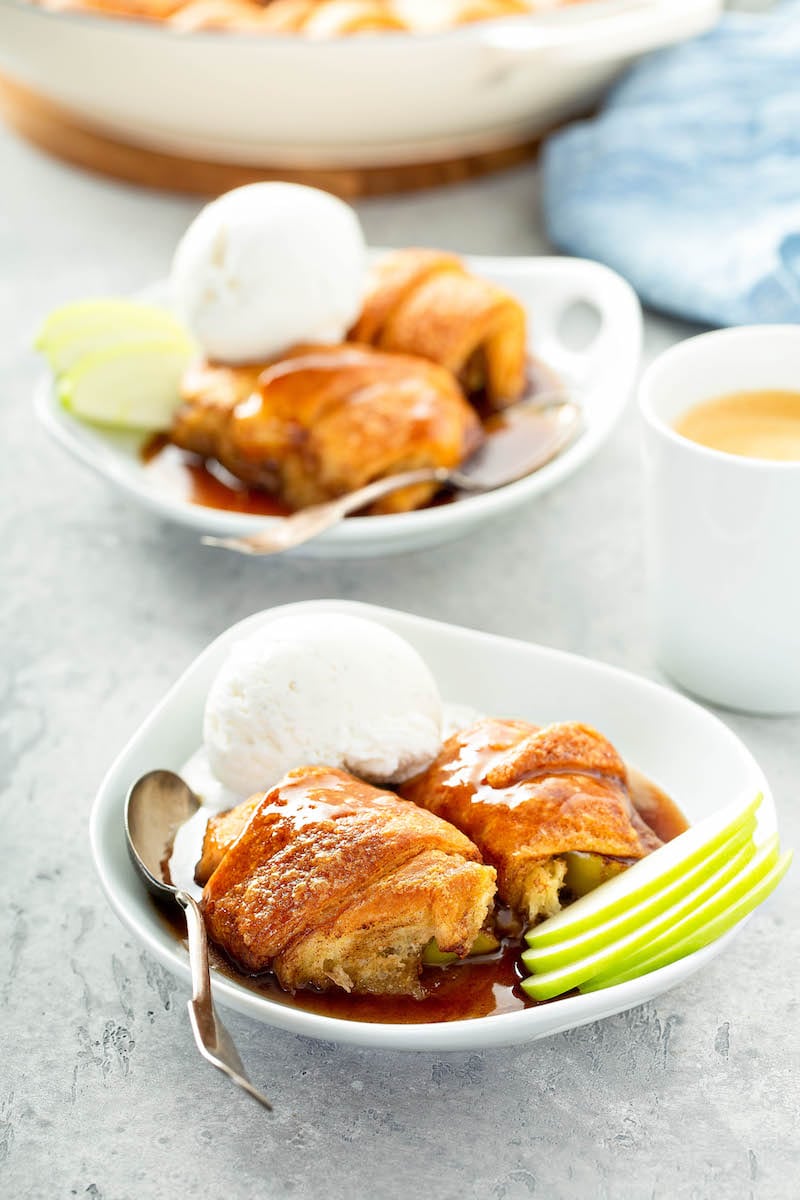 Pastries in bowls with ice cream and apple slices.