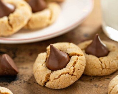 These Peanut Butter Blossoms are a Christmas tradiiton! Sweet peanut butter cookies are rolled in sparkling sugar, with a milk chocolate kiss in the center! #PeanutButterBlossoms #PeanutButterBlossomsRecipe #PeanutButterBlossomCookie #Dessert #ChristmasCookie #Cookie #CookieRecipe #ChristmasCookieRecipe #PeanutButterCookie #PeanutButterCookieRecipe #PeanutButterKissCookies #ChristmasRecipes #PeanutButter