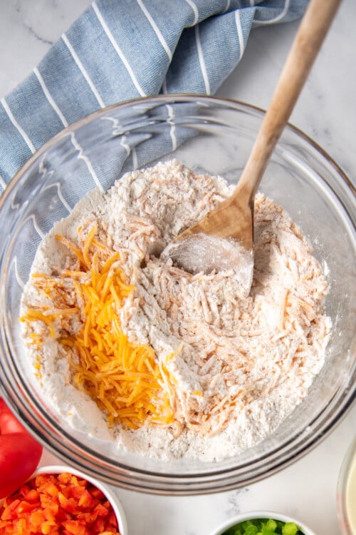 Shredded cheese being stirred into a flour mixture.