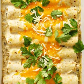Sour cream chicken enchiladas with cheese and cilantro on top.