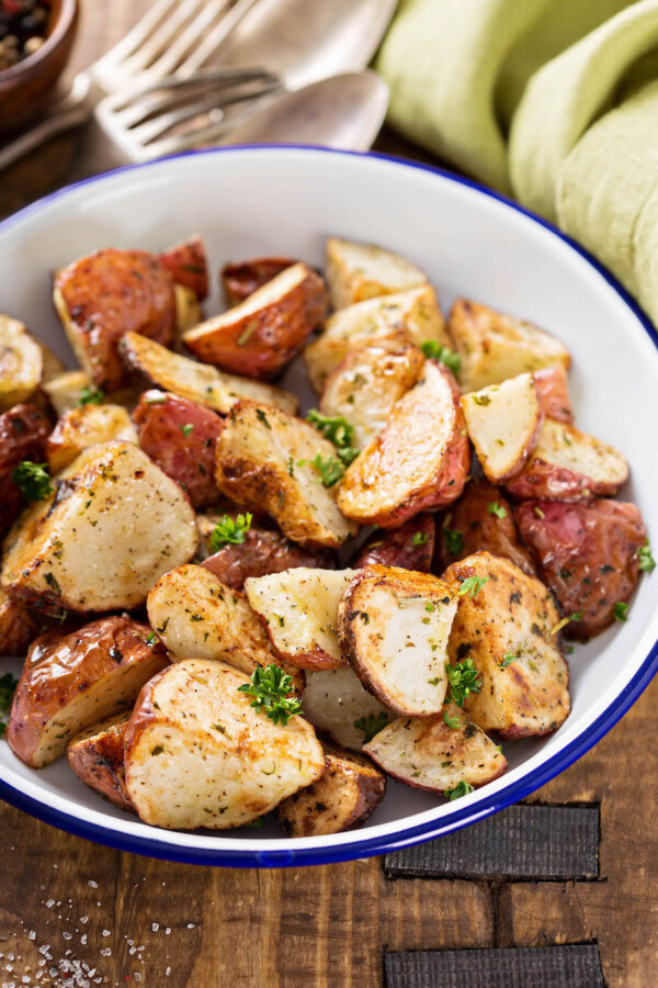 Oven roasted potatoes with herbs cooked in a bowl.