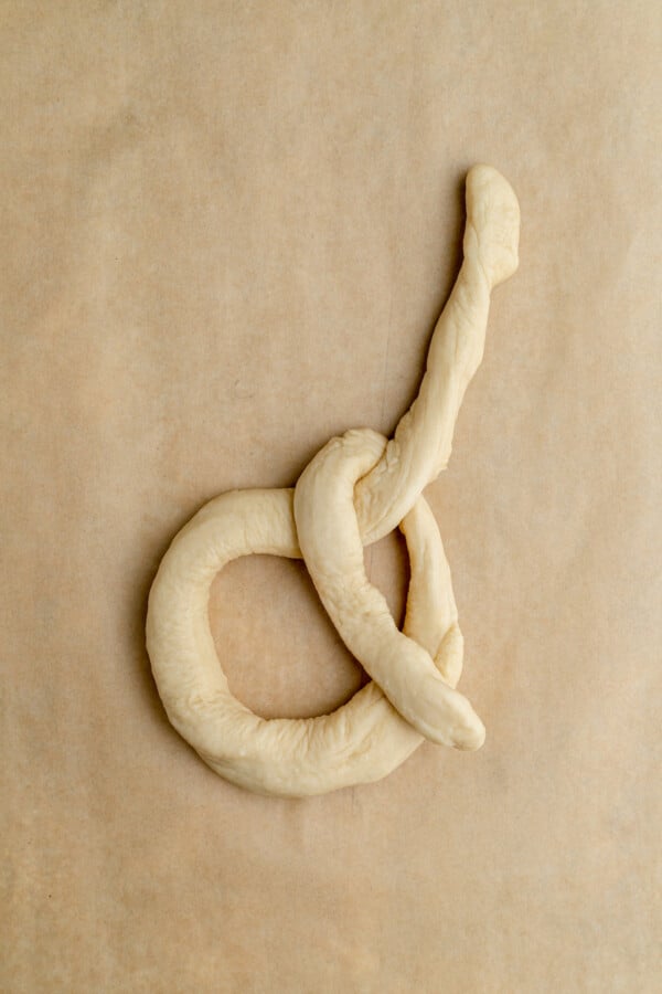 A long rope of raw dough, shaped into a knot.