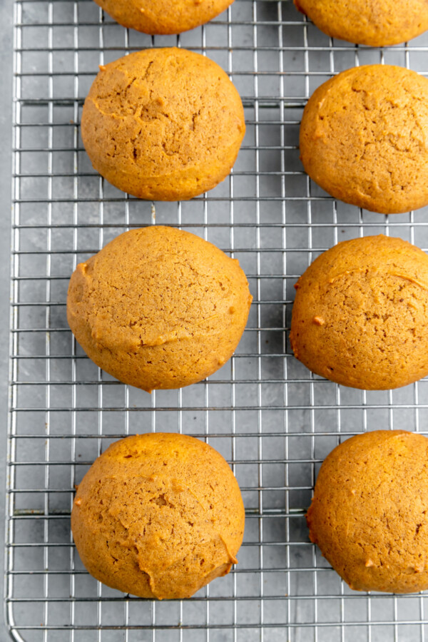 Baked rounds of pumpkin cake, cooling on a wire rack.