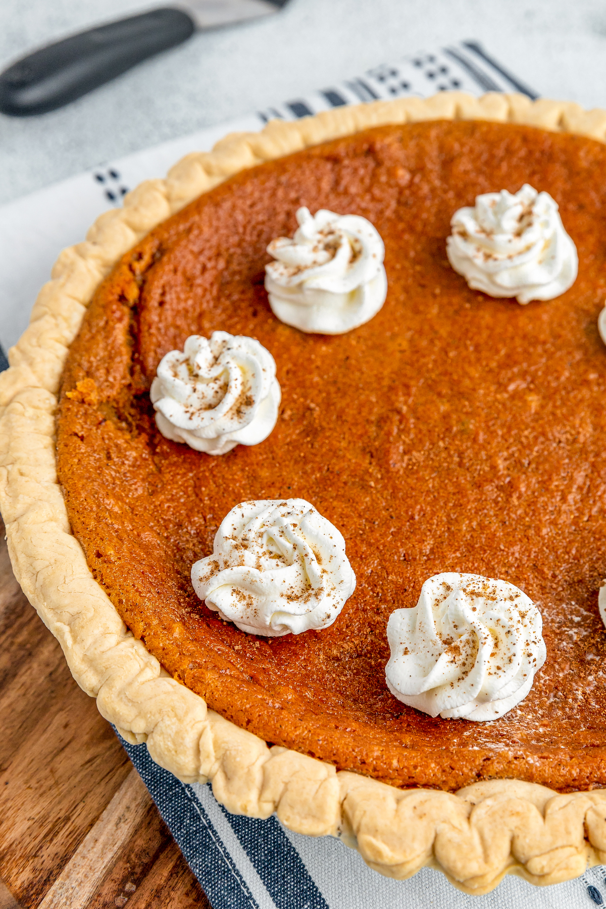A fully baked pie garnished with whorls of whipped cream.