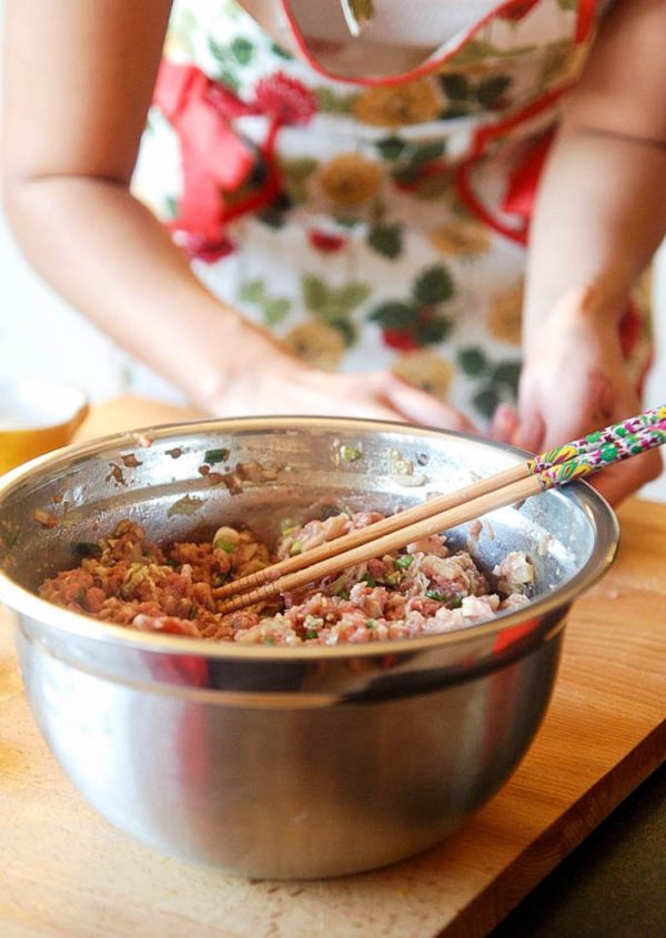 Large bowl of pork filling for Chinese Potstickers with chopsticks. 