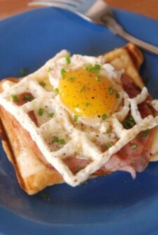 croque madame on a blue plate with a fork