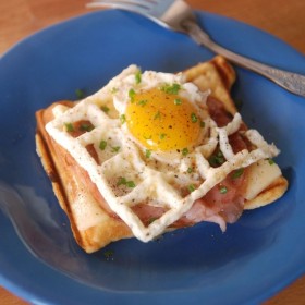 croque madame on a blue plate with a fork