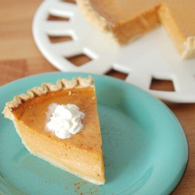 A slice of Sweet Potato Buttermilk Pie topped with whipped cream on a teal plate