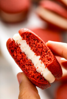 Holding a red velvet whoopie pie with cream cheese filling.