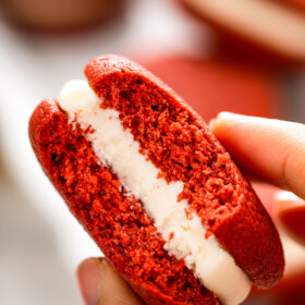 Holding a red velvet whoopie pie with cream cheese filling.