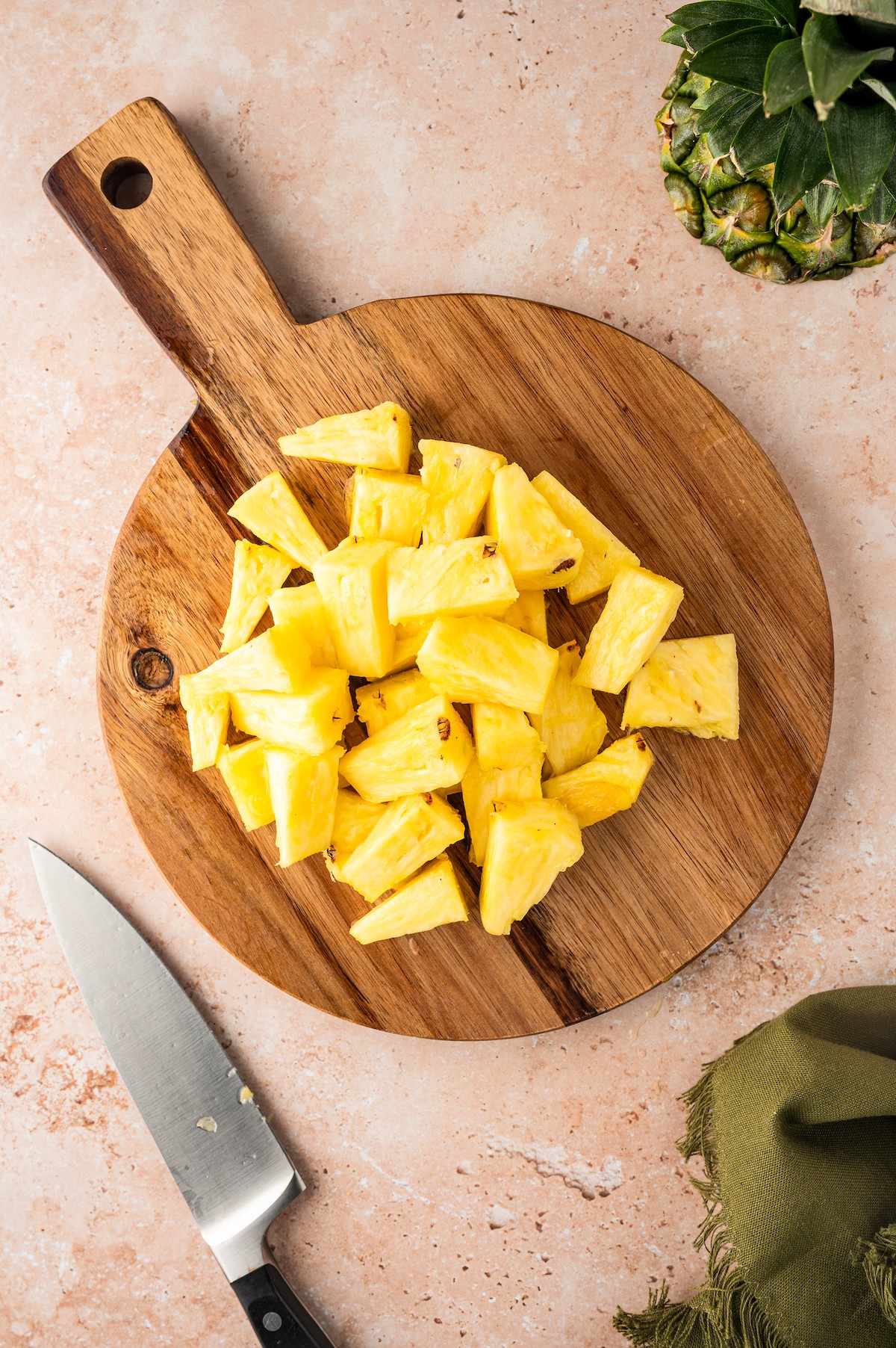 Pineapple chunks on a wooden board.