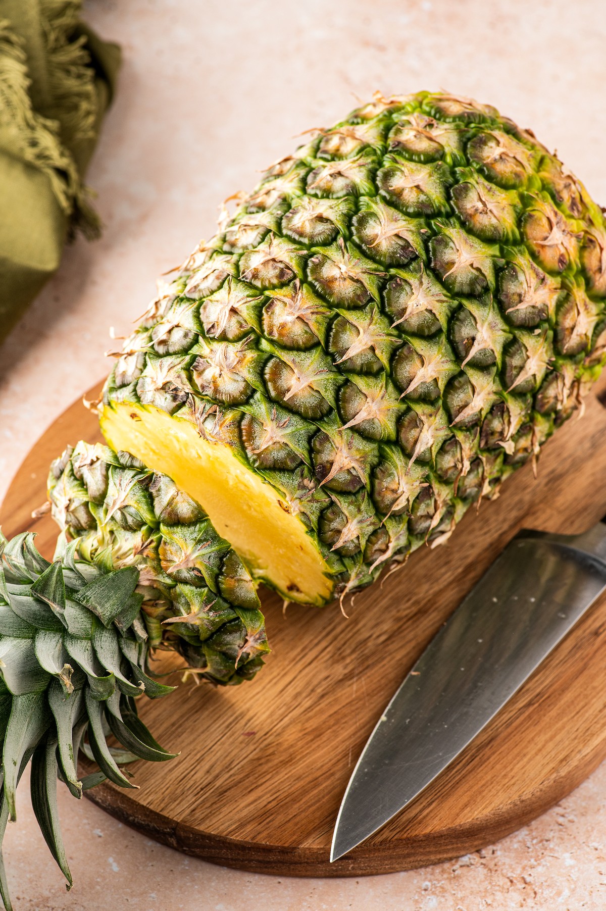 Cutting the top off of a pineapple.