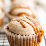 A frosted cupcake, drizzled with dulce de leche and cinnamon sugar.