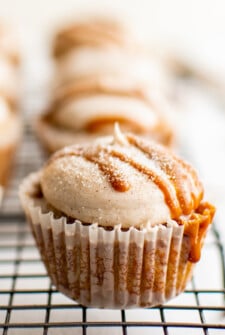 A frosted cupcake, drizzled with dulce de leche and cinnamon sugar.