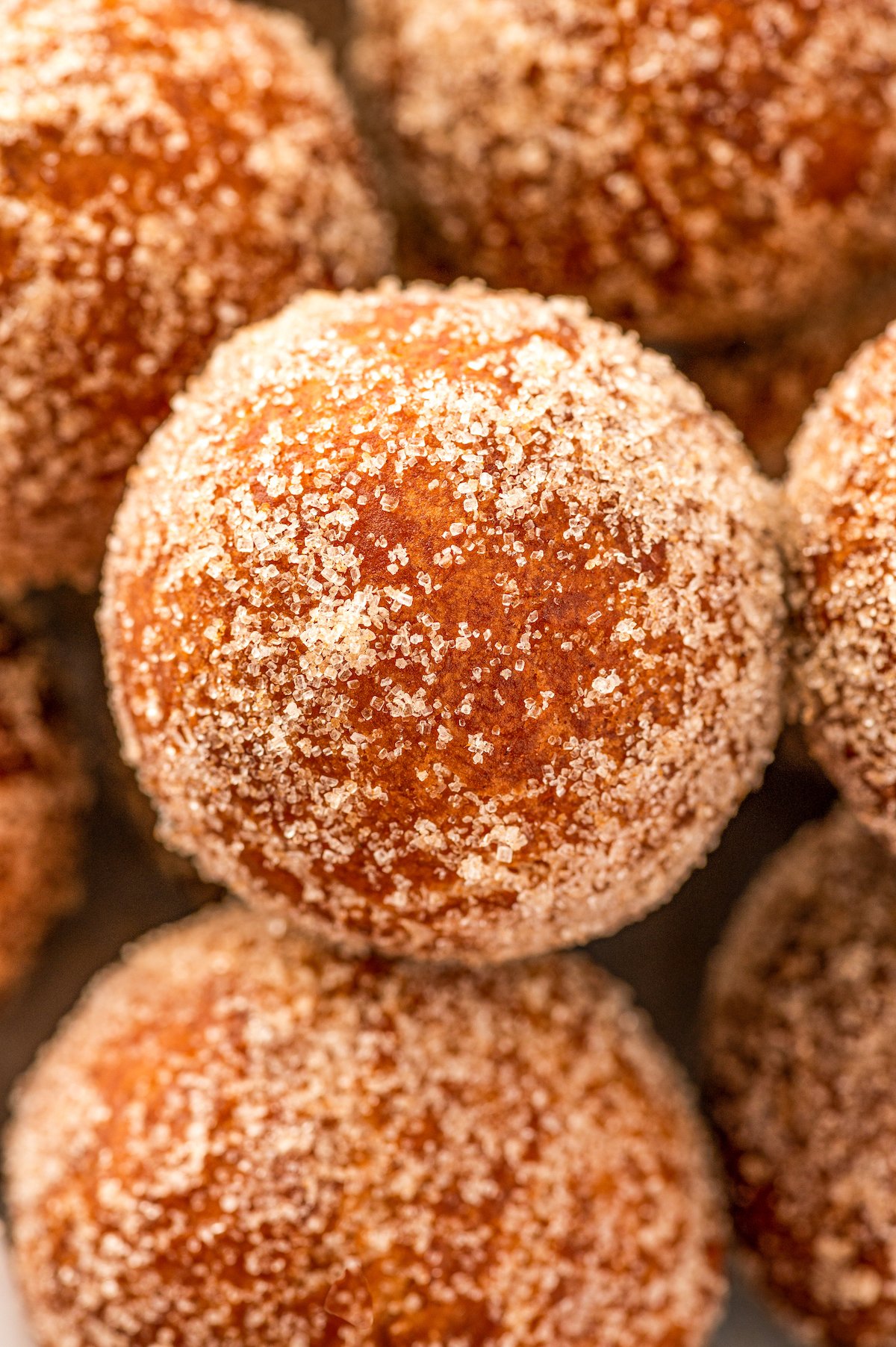 Close up shot of cinnamon sugar donut holes with glistening sugar on the outside.