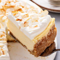 Lifting a slice of cheesecake from a plate with a pie server.