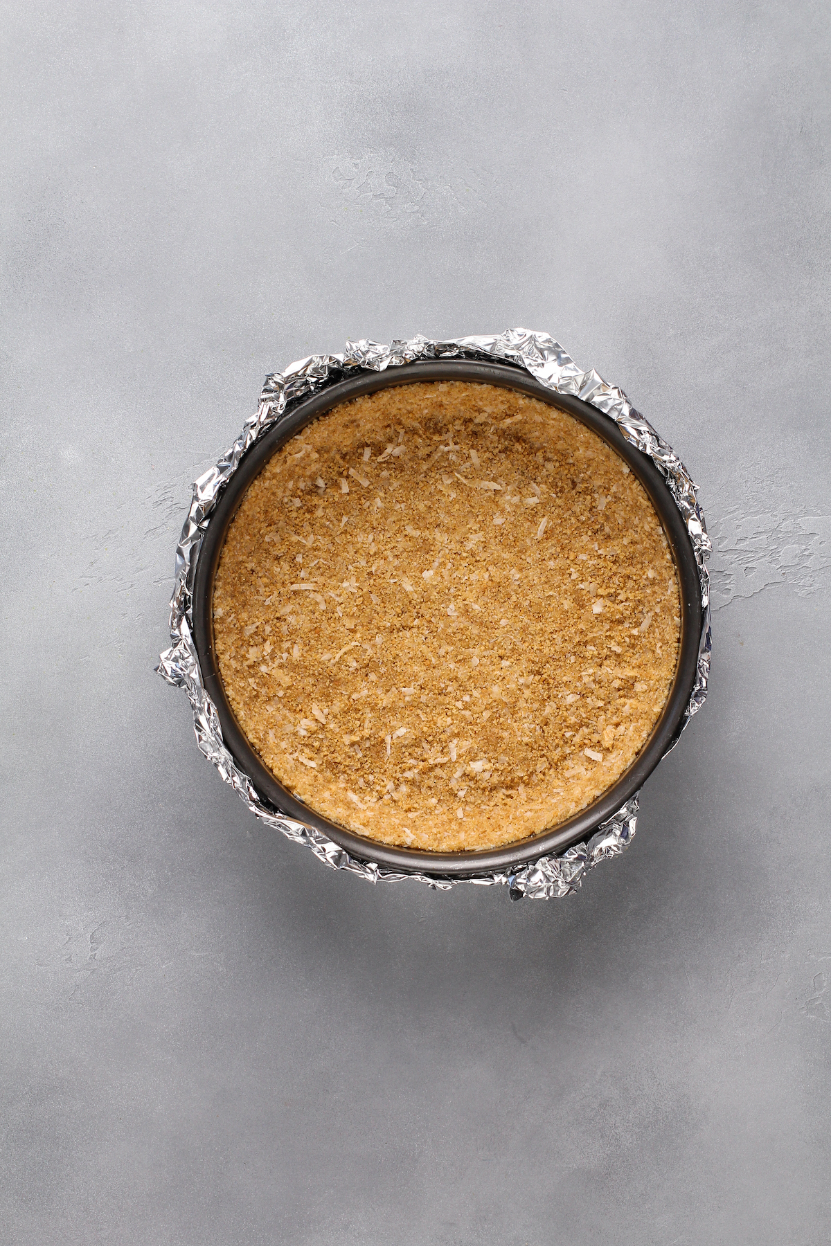 A graham cracker crust pressed into a springform pan.