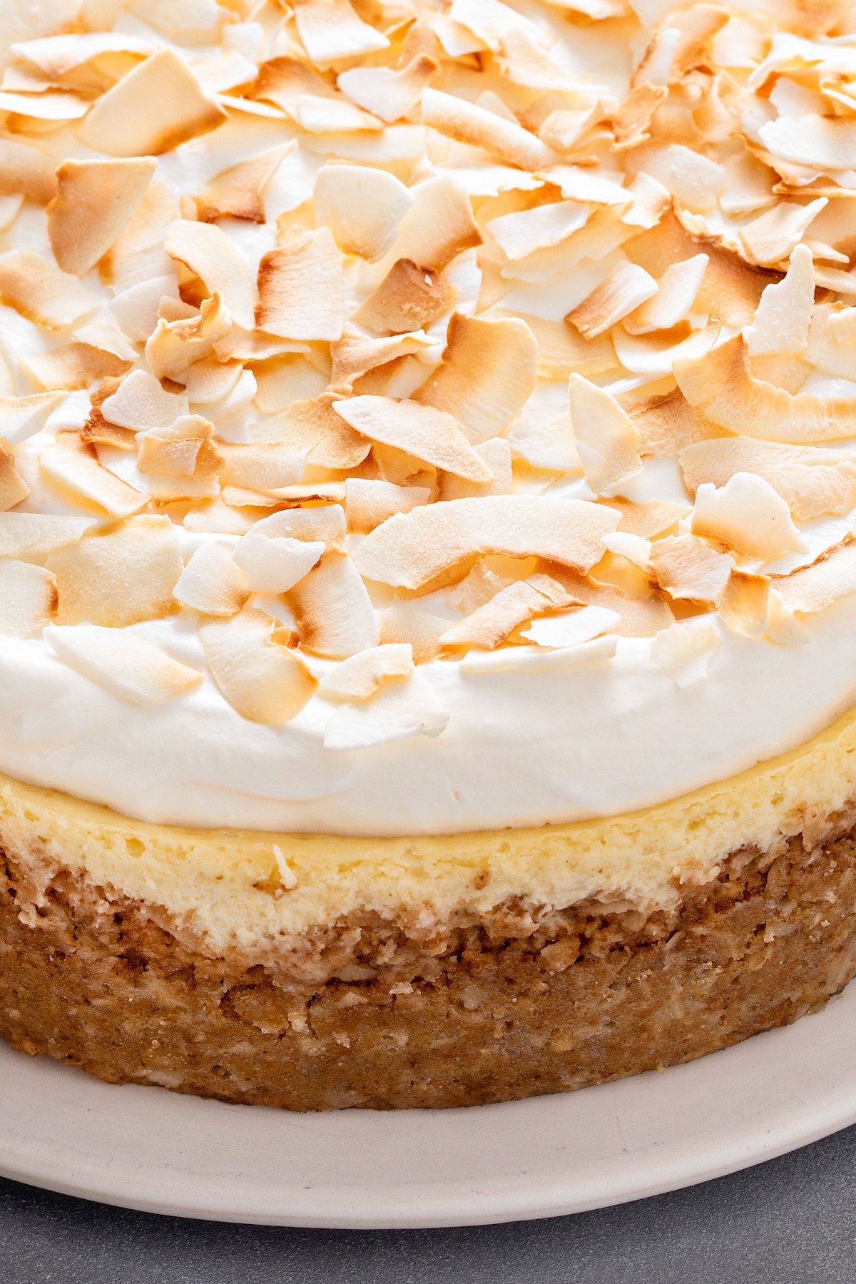 A cheesecake topped with whipped cream and toasted coconut.