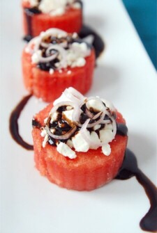 three circles of watermelon with balsamic, feta on and onion.