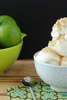 Bowl of lime frozen yogurt with whip cream and crushed graham crackers on top.