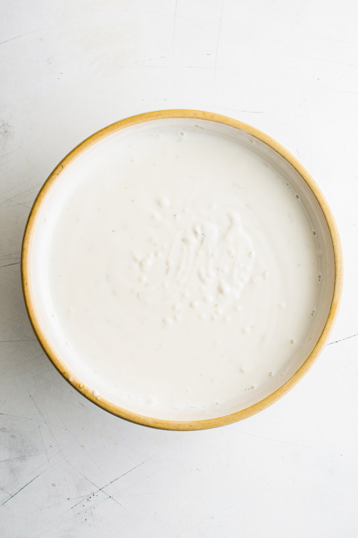 A mixing bowl filled with a lime-yogurt mixture.