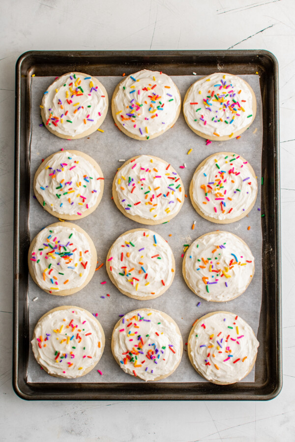Frosted Lofthouse cookies decorated with multicolor sprinkles.