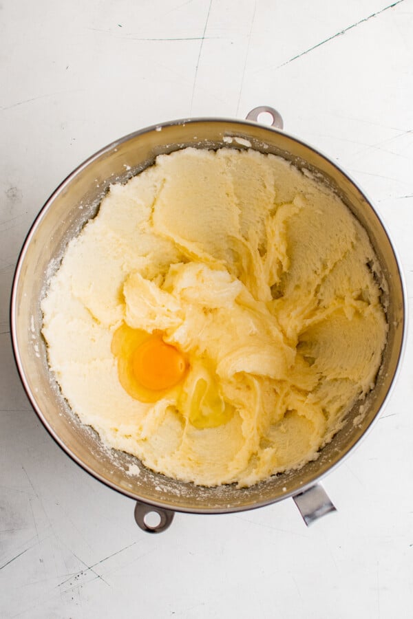 Creamed butter and sugar, with an egg cracked into the bowl.