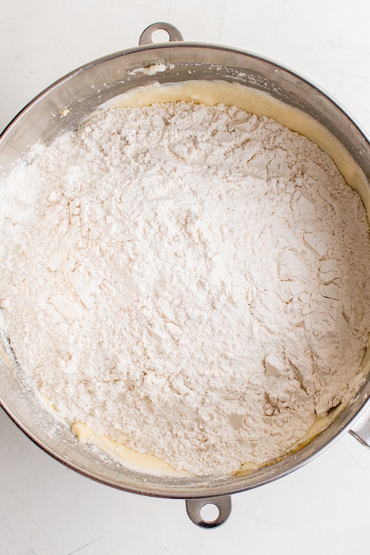 A mixing bowl with dry ingredients poured on top of the creamed butter mixture.