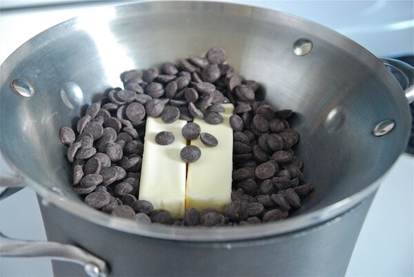Chocolate chips and butter in a double boiler on a stove top.