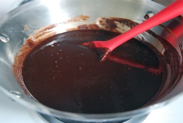 Melted chocolate in a double boiler with a spatula.