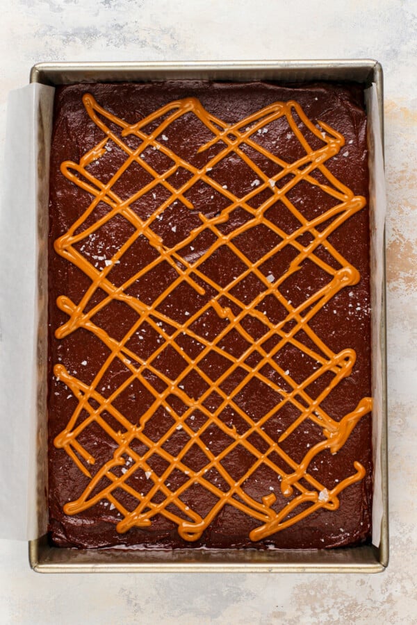 Spreading the brownie batter in the baking dish and adding the caramel swirl.
