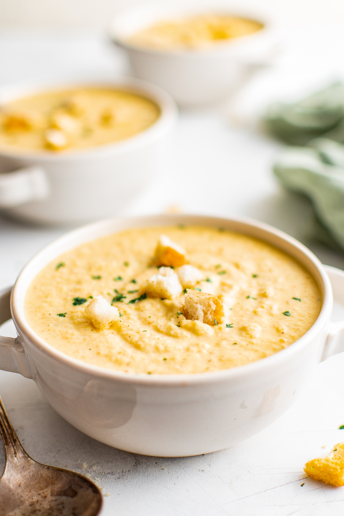 A white bowl filled with roasted garlic cauliflower soup.