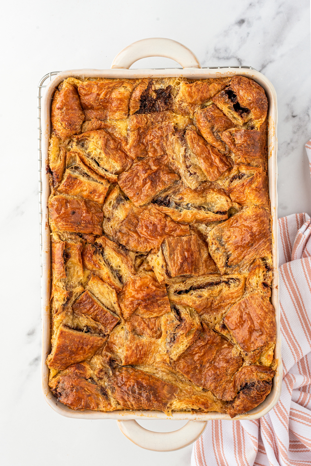 Baked Nutella croissant bread pudding in a large rectangular dish.