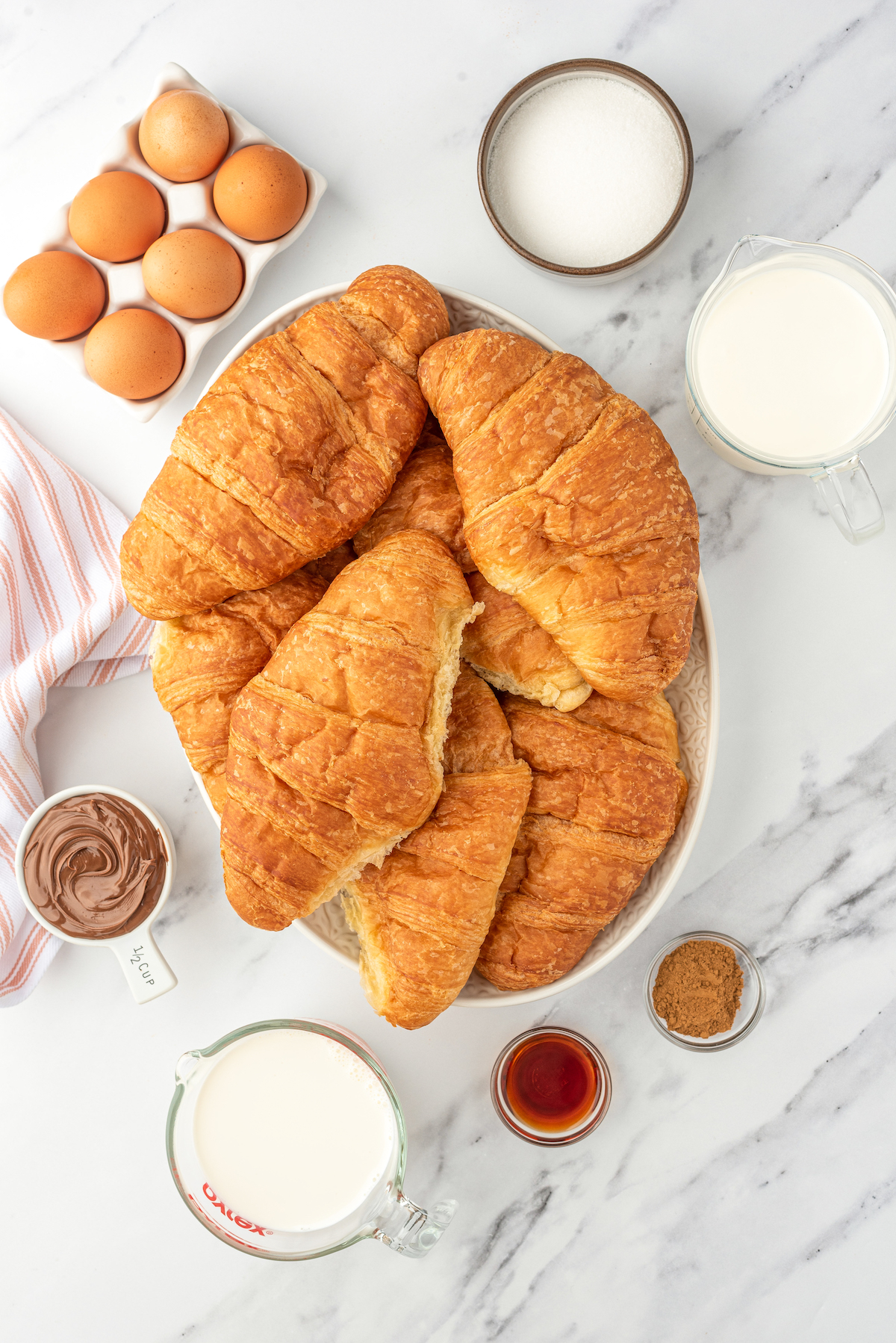 From top left: Eggs, sugar, half and half, Nutella, croissants, heavy cream, vanilla, cinnamon.