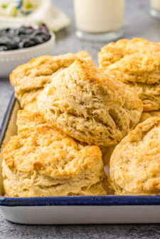 Golden, flaky biscuits piled onto an enamel tray.