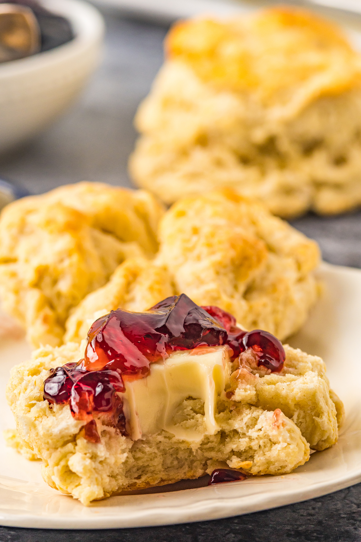 Close-up shot of a biscuit topped with butter and jelly.