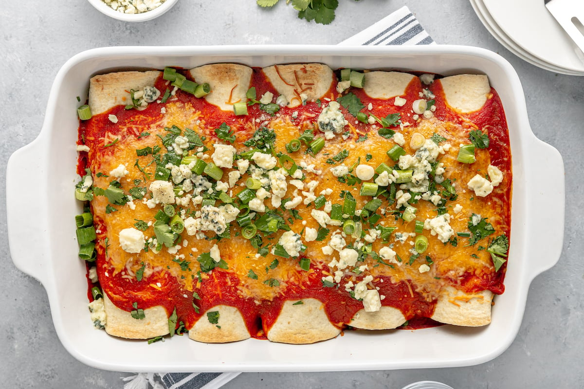 Overhead shot of a white casserole dish with chicken enchiladas.