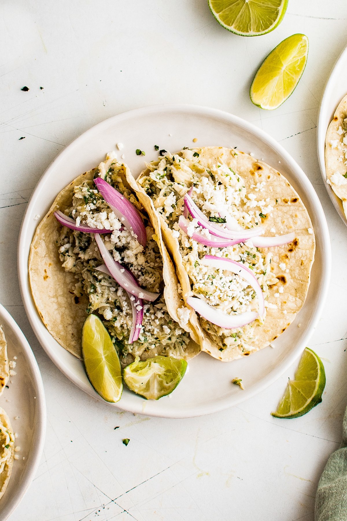 Two salsa verde chicken tacos on a plate.