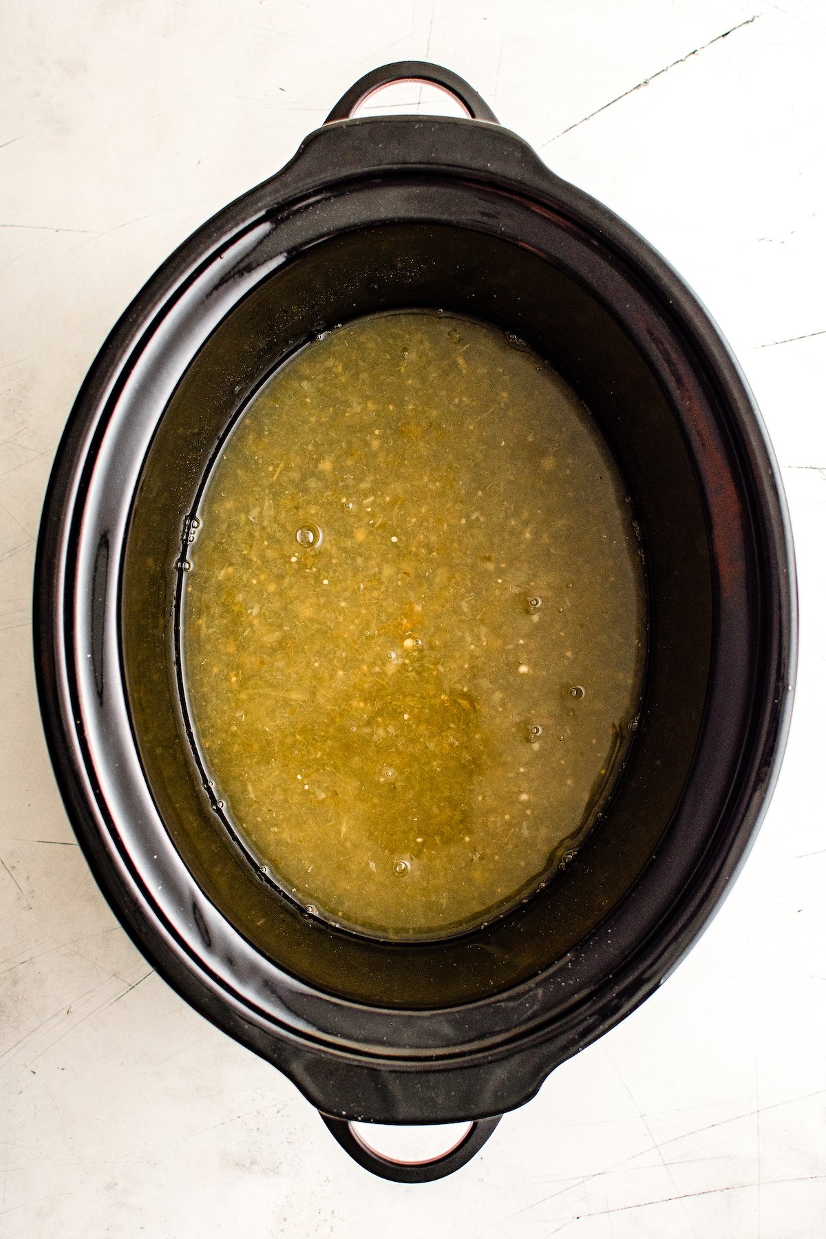 Green salsa sauce in a slow cooker.