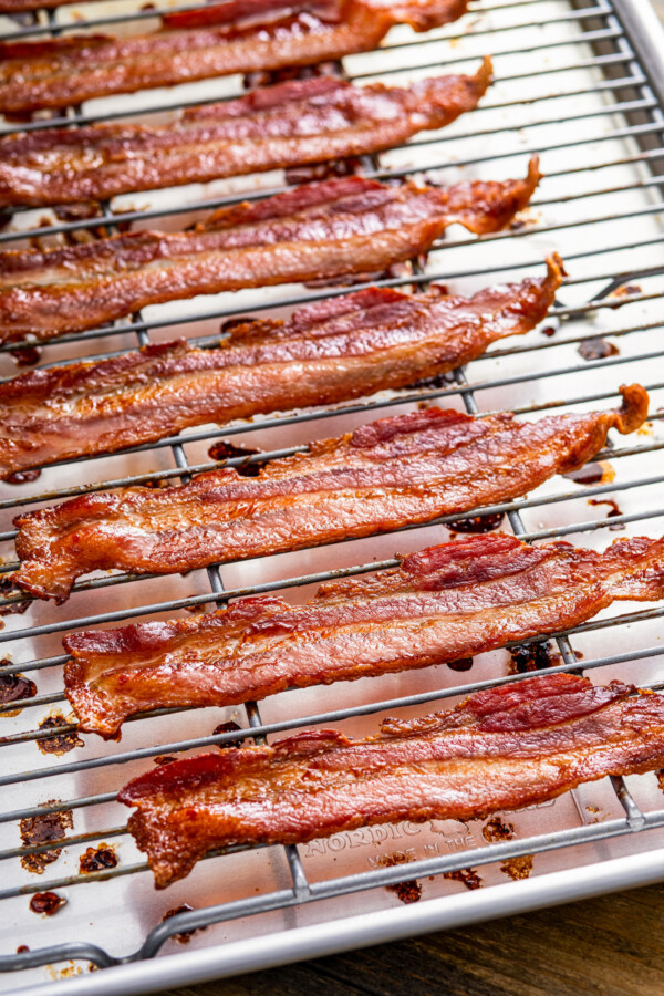 Crispy cooked bacon in the oven cooling on a rack.