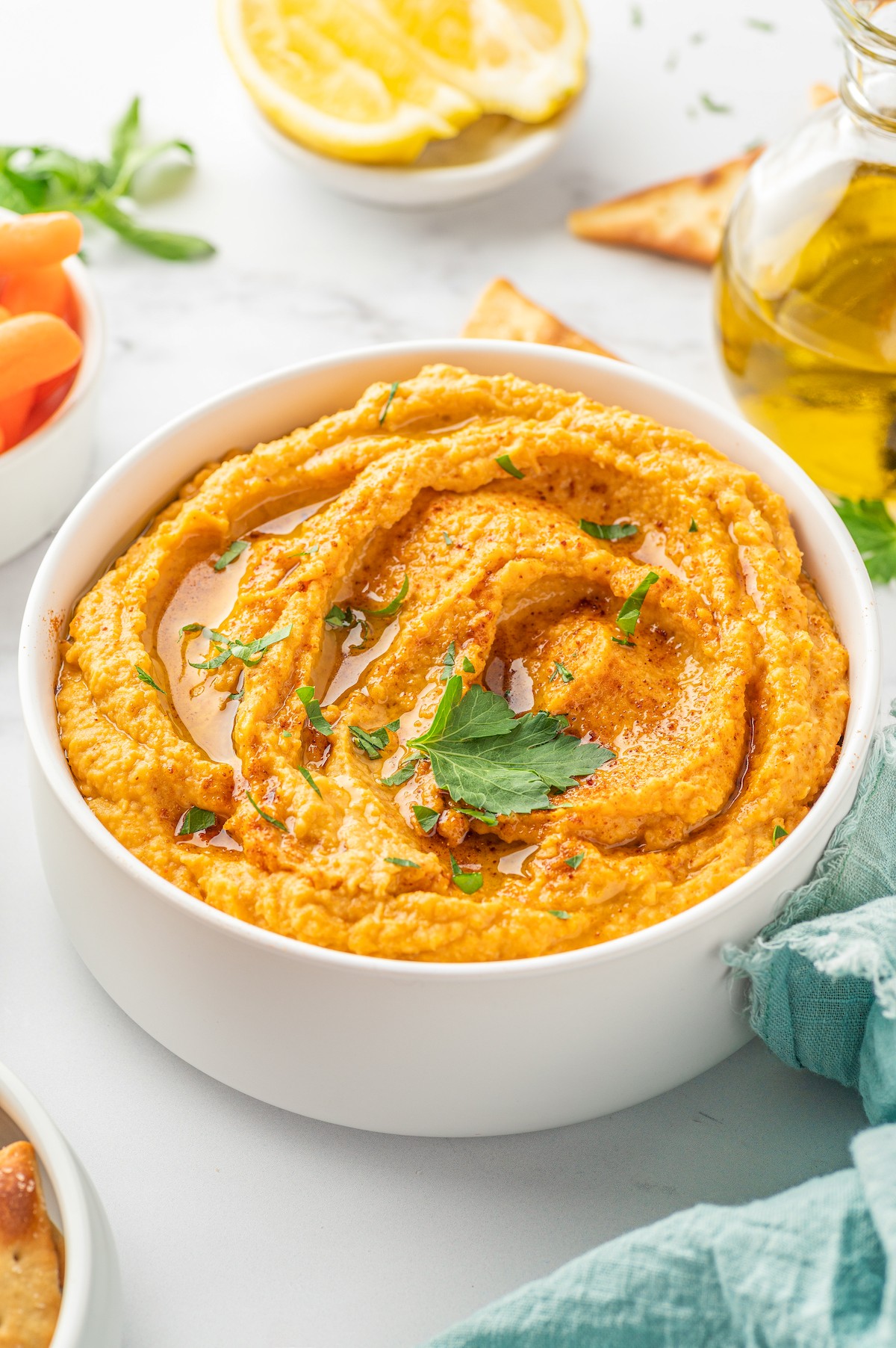 Bowl of sweet potato hummus with a drizzle of olive oil on top.