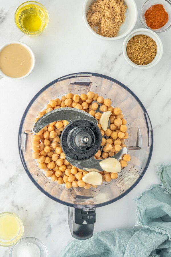 Adding the chickpeas and garlic to the food processor.