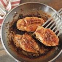 Three Pan-Seared Garlic Butter Brown Sugar Chicken Breasts in a Metal Skillet on a Table