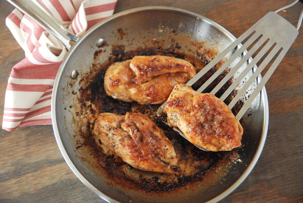 Three Pan-Seared Garlic Butter Brown Sugar Chicken Breasts in a Metal Skillet on a Table