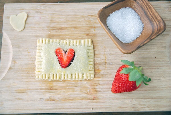 Unbaked strawberry pop tart on a cutting board.