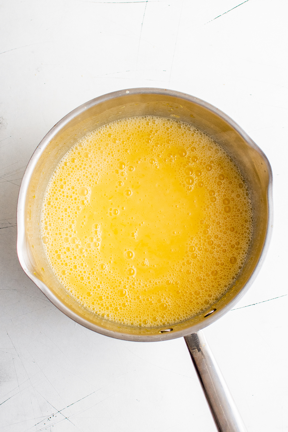 A mixture of lemon, eggs, and sugar in a saucepan.