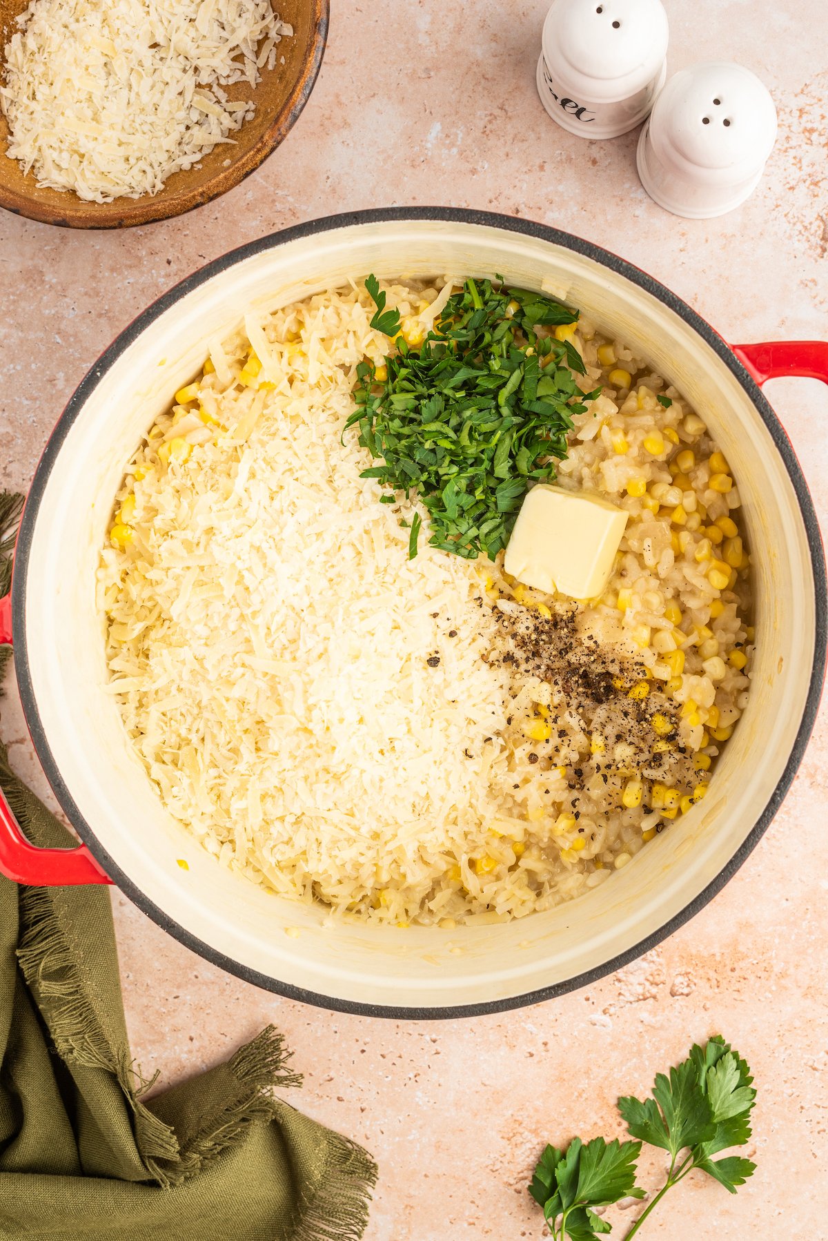 Adding the remaining butter, cheese, and parsley to the pot.