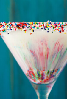 Up close image of cake batter martini with rainbow sprinkles inside and on rim