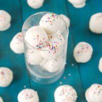 Cake batter truffles with rainbow sprinkles in a cup.